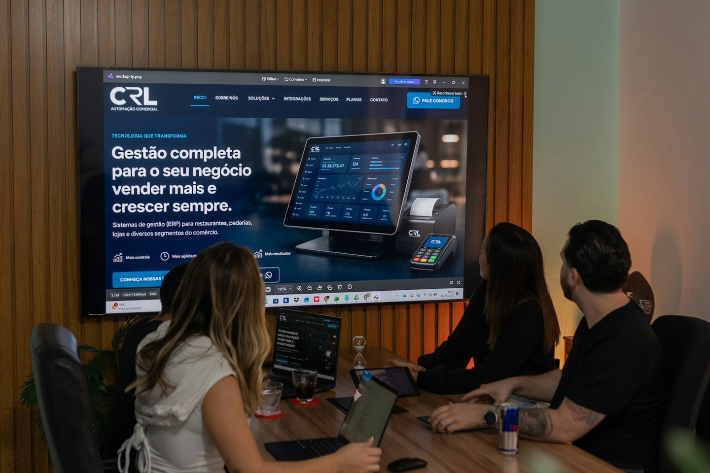 Tre professionisti esaminano un software di gestione aziendale su uno schermo in sala riunioni.